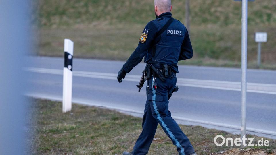 Ein bewaffneter Polizist geht auf einer Straße am Ortsrand von Parsberg. Bild: Armin Weigel