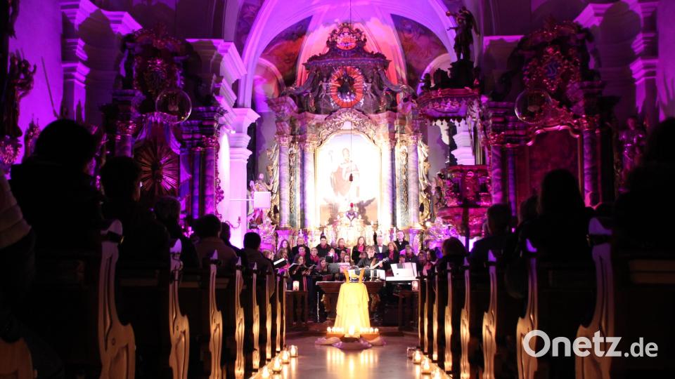 Kerzen und nur wenig elektrisches Licht erhellen die Kirche Sankt Ulrich beim Konzert von „Ganz und Gar“ im Rahmen seiner „Zugehört und Nachgedacht“- Reihe. Dieses Mal geht es um den Frieden. Bild: jag