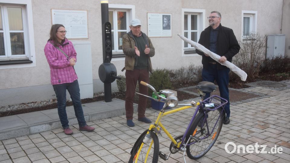 Die Vohenstraußer Pfarrerin Carmen Riebl (links) übergibt die Simultankirchenfahne an den Kohlberger Pfarrer Marcio Trentini. Der Vorsitzende des Fördervereins Simultankirchen in der Oberpfalz, Hans-Peter Pauckstadt-Künkler, präsentiert zudem das gelb/violette Symbolradl. Bild: fz