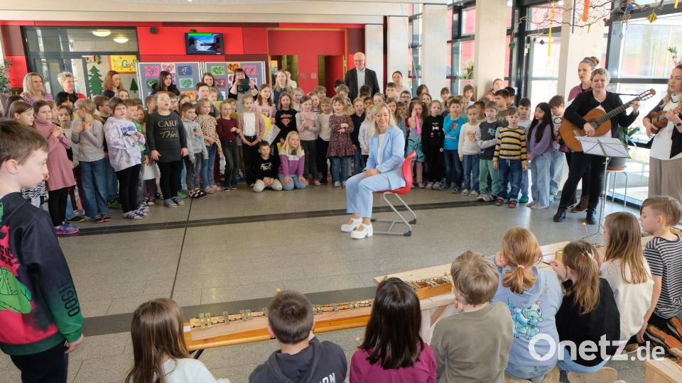 Die Überraschung ist gelungen. In der Aula begrüßen die Schulkinder die neue Rektorin mit Tanz und Gesang. Bild: Fred Lehner