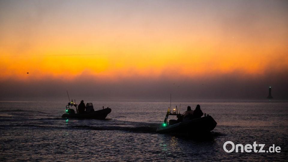 Einsatzkräfte begleiteten das Schiff bei seiner Ankunft in der Dämmerung. Bild: Sina Schuldt/dpa