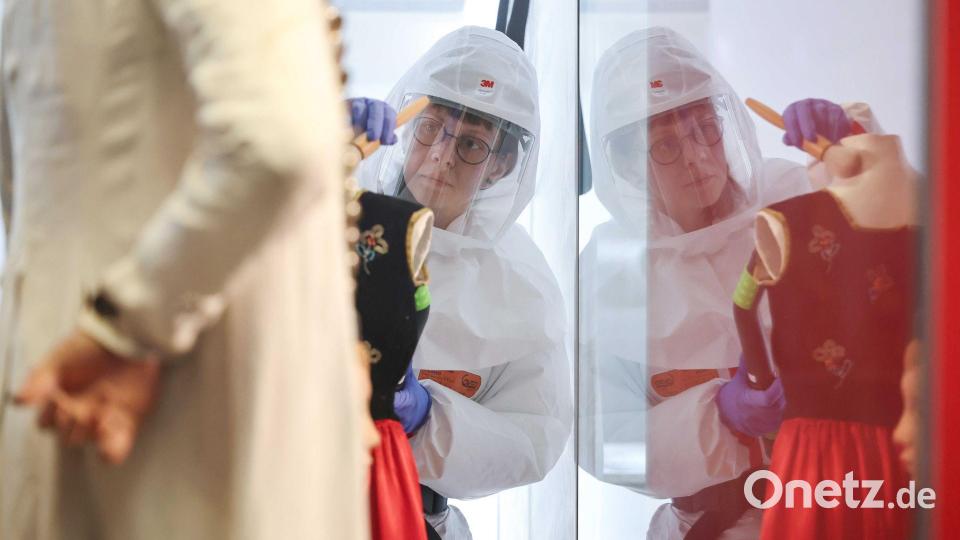 Mit Pinsel und Staubsauger wird die Tracht gereinigt. Bild: Daniel Löb/dpa