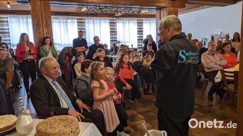Josef Stangl (vorne, sitzend) genießt mit Ehefrau Angela, den Kindern und der Enkelschar das Ständchen der Stadtkapelle Neustadt, geleitet von Karl Wildenauer, zu seinem 80. Geburtstag. Bild: kwl