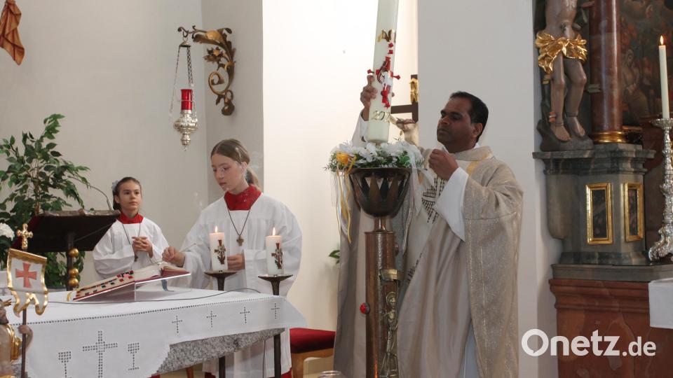 Pfarrer John Subash Vincent stellte die entzündete Osterkerze auf. Bild: pi
