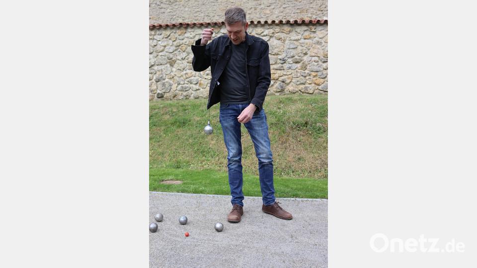 Stadtrat Ralf Volkert zeigt, wie man die Kugeln mit dem Magneten wieder aufnehmen kann. Personen mit Rückenbeschwerden werden diese Möglichkeit schätzen. Bild: mfh