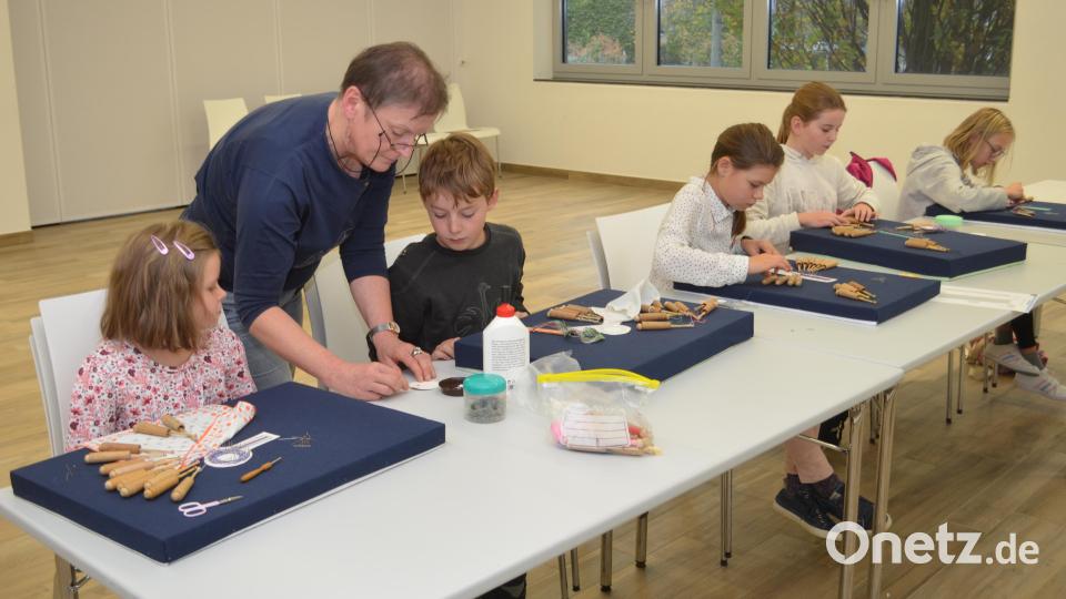 Sticker wie Fische oder Blüten und ein Freundschaftsbändchen klöppeln die Kinder unter Anleitung von Sabine Heibl. Bild: fz