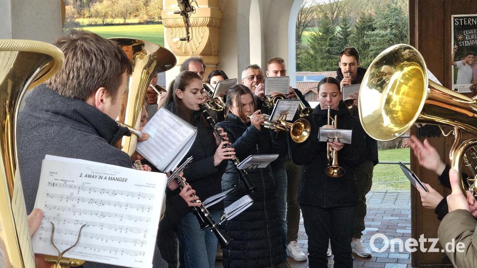 Weihnachten in Unterauerbach: Von dem Kirchenprotal aus spielte die Blaskapelle die Weihnachtslieder ins Auerbachtal hinaus. Bild: ga