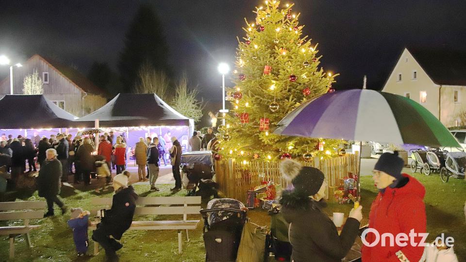 Schirme sind bei der Dorfweihnacht in Etzenricht am Samstagabend nur sporadisch notwendig. Vom Wetter lassen sich die Gäste aber nicht aufhalten und verbringen ein paar schöne Stunden am Dorfplatz. Bild: war