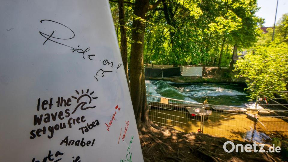 Surfer hinterlassen Trauerbekundungen auf einem Surfbrett an der Unglücksstelle. Bild: Peter Kneffel/dpa