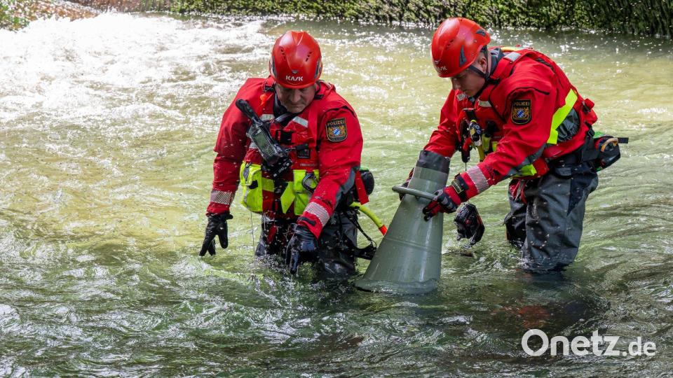 Polizeitaucher untersuche mit einem Schauglas den Boden des Eisbachs. Bild: Peter Kneffel/dpa