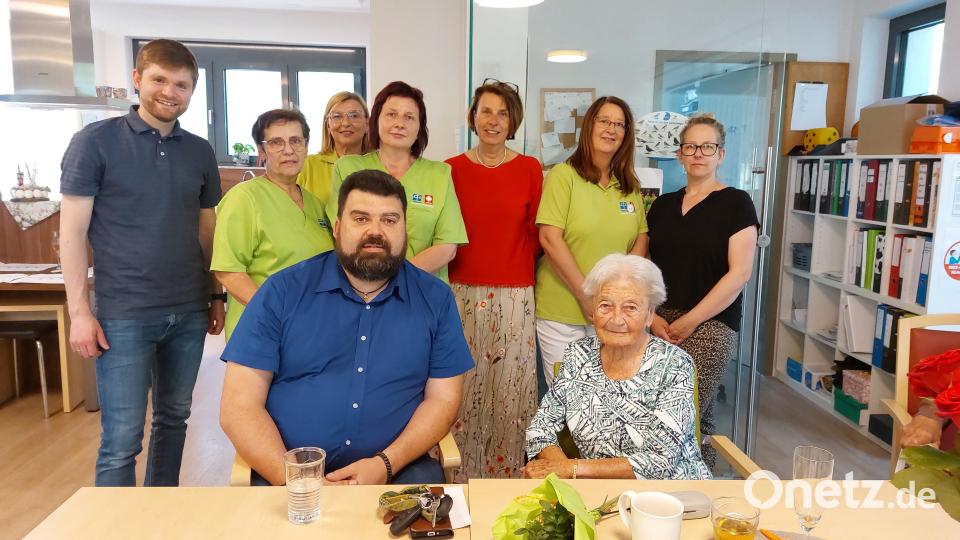 Pfarrer Daniel Götzfried (stehend links), die Mitarbeiterinnen der Tagespflege mit Birgit Singer-Grimm (Geschäftsführerin der Ökumenischen Sozialstation) in ihrer Mitte sowie Bürgermeister Stefan Frank (sitzend, links) überraschten der Jubilarin Käthe Royer (sitzend, rechts) mit einem spontanen Ständchen. Bild: mfh