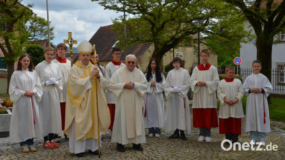 Vor dem Kirchenportal freuten sich Weihbischof Reinhard Pappenberger und Pfarrer Gerhard Schmidt über den musikalischen Beitrag der Trachtenkapelle aus Waldthurn. Bild: dob