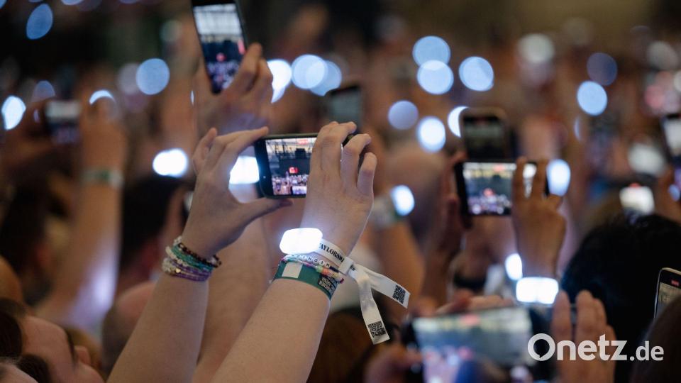 In ein Meer aus Smartphone-Bildschirmen zu schauen, findet nicht jeder Künstler gut. (Symbolbild) Bild: Marius Becker/dpa