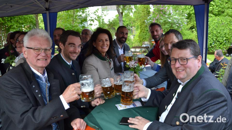 Gemeinsam stießen Seniorchef Erhard Scheuerer (vorne links) und Juniorchef Uli Scheuerer (hinten rechts) zum frisch gezapften Gerstensaft mit den Ehrengästen an. Bild: gi