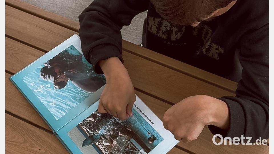 Franz Schuh (7) freut sich schon auf seine Reise zu den Delfinen. Auch ein Fotobuch bereitet ihn darauf vor. Bild: Lisa Schuh