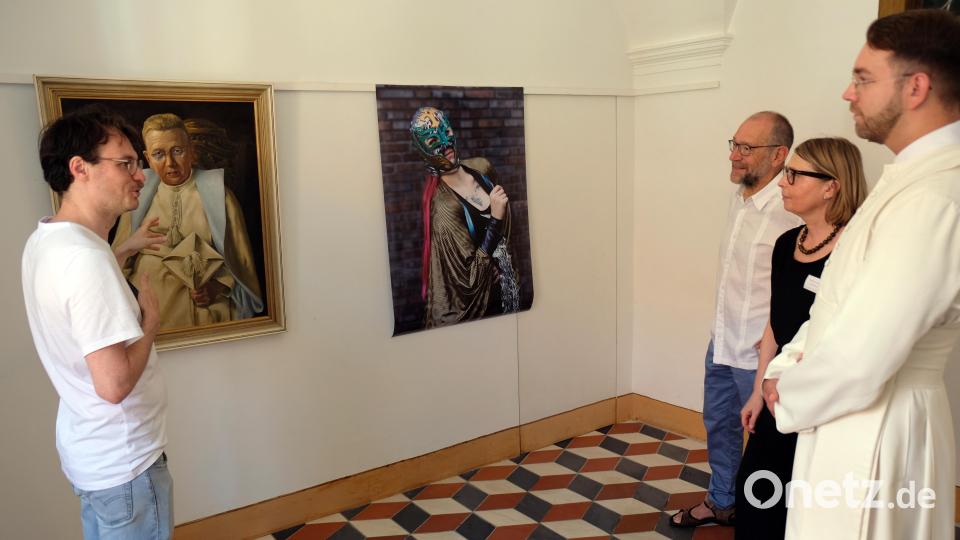 Speinsharts Kulturmanager Moritz Kellner (li) erläutert den Besuchern der Vernissage das Kontrastprogramm alter und neuer Porträts. Bild: do