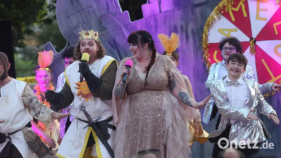 König Artus (Michael Zanner) singt und tanzt mit der &quot;Fee aus dem See&quot; (Stephanie Meier) und den Rittern der Tafelrunde. Bild: Hirsch