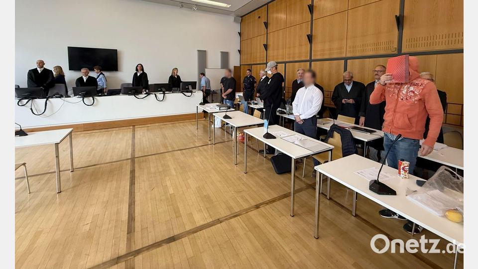 Die Angeklagten stehen im Sitzungssaal vor ihren Verteidigern. Bild: Ulf Vogler/dpa