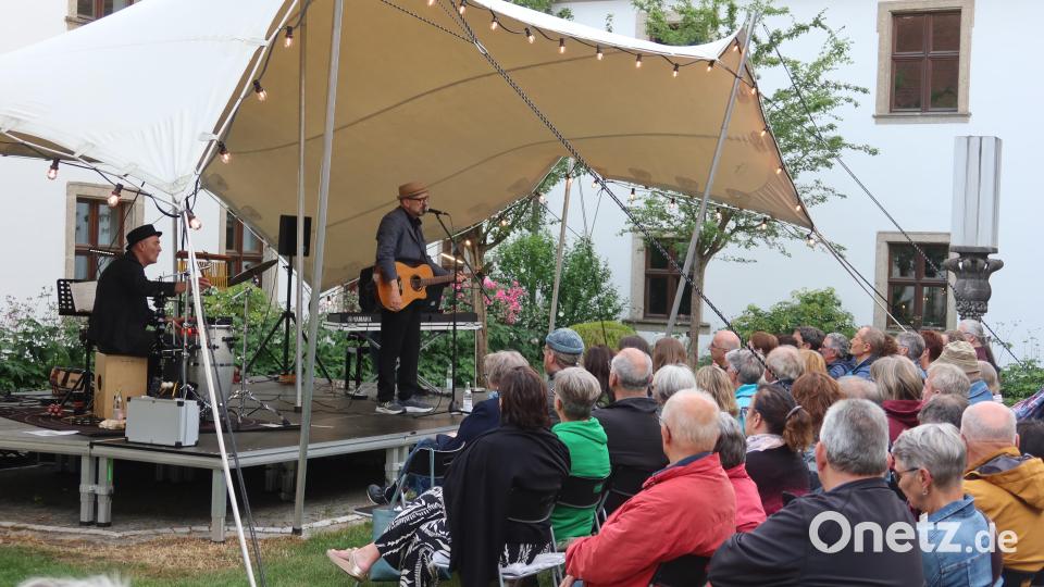 Hubert Treml steht im Innenhof der Weidener Regionalbibliothek mit seiner Band auf der Bühne. Bild: Kunz