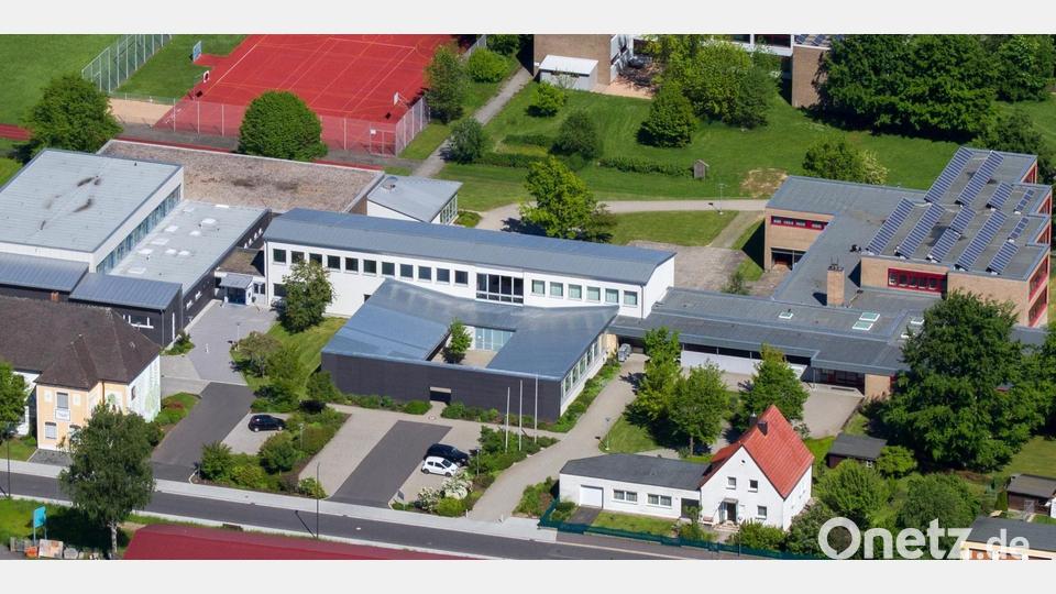 Die Realschule im Stiftland aus der Vogelperspektive: Links die sanierte Turnhalle mit dem Hallenbad und dem Sportplatz dahinter, in der Mitte der Verbindungstrakt mit dem vorgelagerten Bau mit Innenhof, rechts der Klassentrakt mit den roten Fenstern und den Solarmodulen. Bild: Realschule im Stiftland/Tobias Neubert