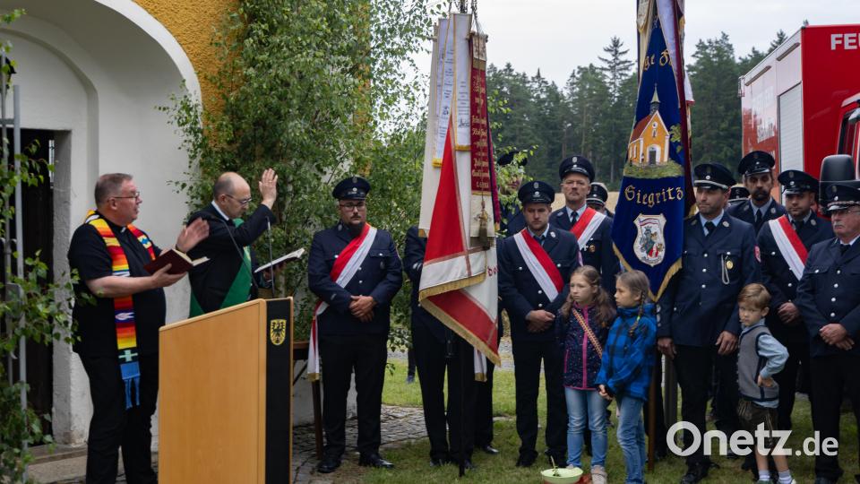 Pfarrer Thomas Berthold und Diakon Martin Schraml segnen das neue Feuerwehrfahrzeug der Freiwilligen Feuerwehr Siegritz vor der St.-Anna-Kapelle. Bild: Roland Wellenhoefer