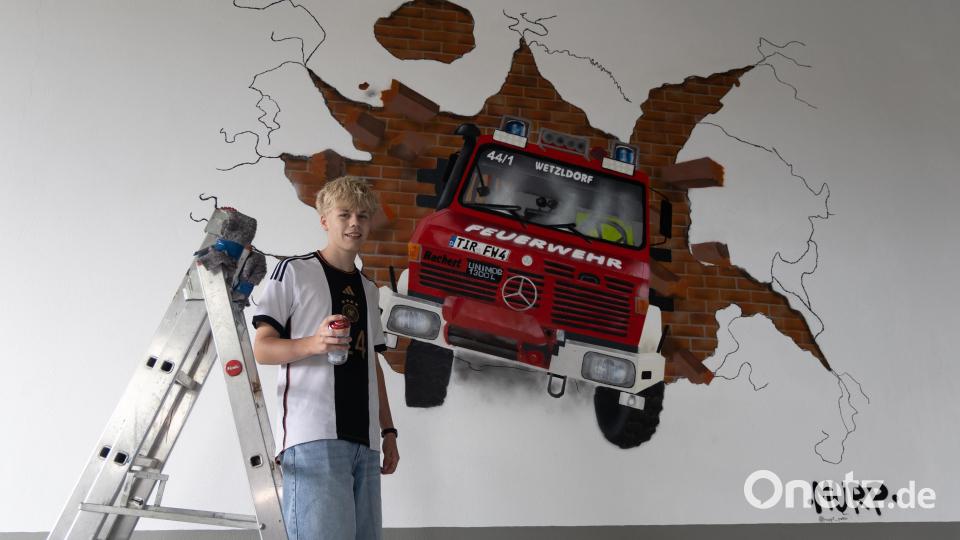 Matti (15) vor seinem beeindruckenden Kunstwerk: Der Unimog der Feuerwehr Wetzldorf, detailgetreu auf die Hallenwand gesprayt. Bild: Roland Wellenhoefer