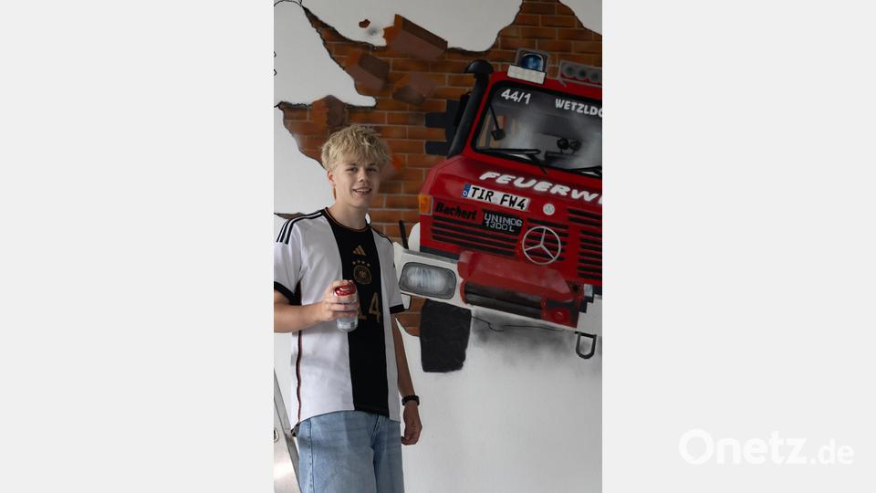 Matti (15) vor seinem beeindruckenden Kunstwerk: Der Unimog der Feuerwehr Wetzldorf, detailgetreu auf die Hallenwand gesprayt. Bild: Roland Wellenhoefer