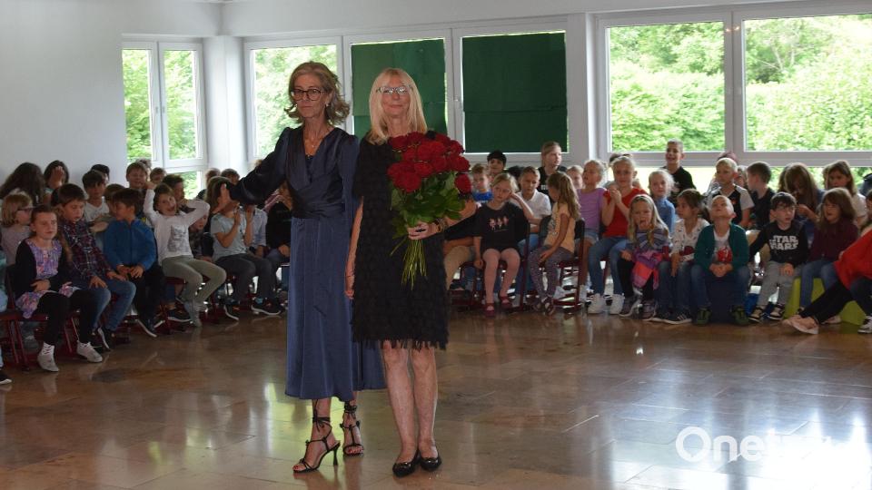 Zum letzten Mal steht die scheidende Lehrerin Monika Ziechaus im Kreis der Kinder der Erasmus-Grasser-Grundschule im Mittelpunkt des Schulgeschehens mit Rektorin Sabine Lubich. Von den Kindern aus der ersten und zweiten Klasse hatte sie Rosen überreicht bekommen. Bild: bö