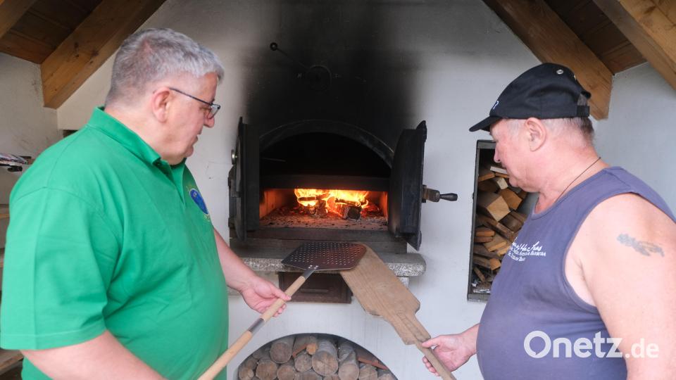 Die Backofenwarte Thomas Buchner und Sigi Schell (von links) heizten den Ofen an, um darin frische Pizzen zu backen. Bild: Fred Lehner