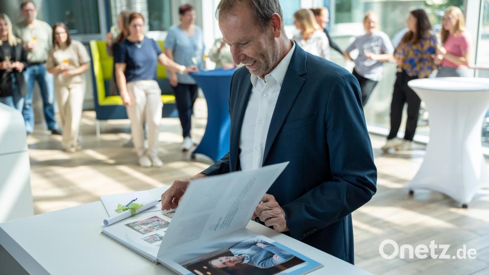 Die Überraschung ist gelungen. Neben einem Reisegutschein gab es von der Geschäftsführung und den Gesellschaftern von Oberpfalz-Medien auch ein Fotobuch mit Erinnerungen der vergangenen 15 Jahre für Geschäftsführer Thomas Maul. Bild: Franka Eichl