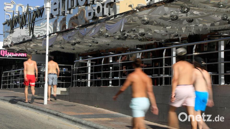 Junge Männer gehen mit nacktem Oberkörper auf Mallorca spazieren. (Archivbild) Bild: Clara Margais/dpa