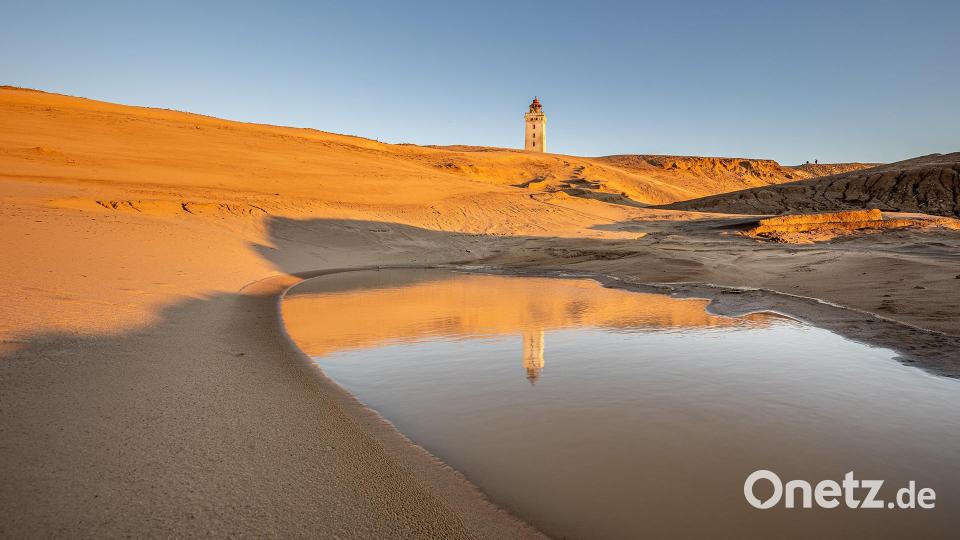 Der Leuchtturm in der Wanderdüne Rubjerg Knude im herbstlichen Sonnenuntergang. Um ihn vor dem Absturz ins Meer zu bewahren, wurde er vor wenigen Jahren auf Schienen gesetzt und als Ganzes ein Stück von der Steilküste weggezogen. Bild: Peter Müller