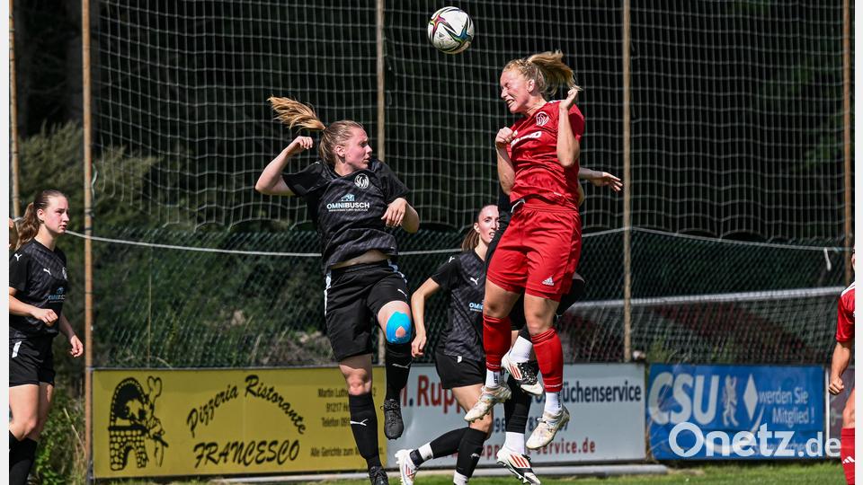 Anne Wagner vom TSV Theuern (rotes Trikot) gewinnt ein Kopfballduell gegen ihre Gegnerin vom SV Neusorg. Am Ende gewinnen die Fußballerinnen vom TSV das Freundschaftsspiel mit 1:0. Bild: Loeffler, Jonas
