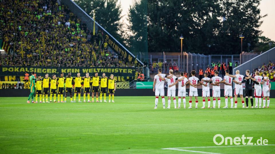 Gedenkminute für Ex-Fußballer Frank Mill, der bei beiden Clubs spielte. Bild: Christoph Reichwein/dpa