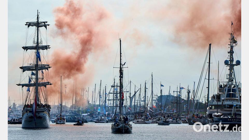 Sail in Amsterdam: Oranger Rauch kündigt den Beginn der Parade von Großseglern vor der niederländischen Hauptstadt an. Bild: Peter Dejong/AP/dpa
