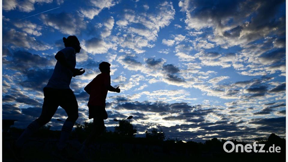 Frühsport in der Hauptstadt: Zwei Jogger laufen am Morgen in Berlin unter einem bewölkten Himmel. Bild: Sebastian Gollnow/dpa