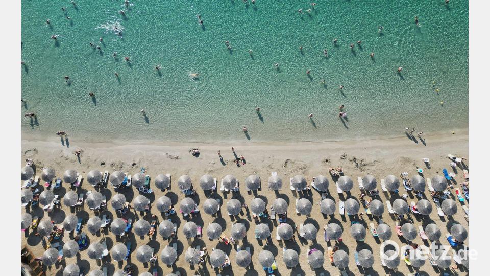 In Reih und Glied: Menschen genießen das Meer am Avlaki-Strand etwa 42 Kilometer östlich von Athen. Bild: Thanassis Stavrakis/AP/dpa