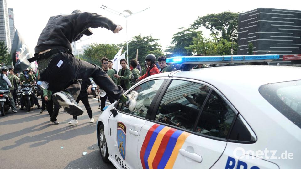 Massenproteste gegen die Regierung in Indonesien: ein Demonstrant attackiert ein Polizeiauto. Bild: Tatan Syuflana/AP/dpa