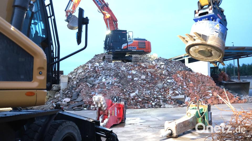 Ein Bagger schüttet auf dem Gelände der Firma Metz in Schwandorf zerkleinertes Material zur Pulverisierung in den Bauschutt-Brecher (Hintergrund). Bild: Hirsch