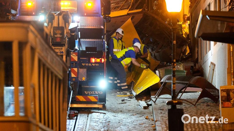 Arbeiter beseitigen die Trümmer einer entgleisten und verunglückten Standseilbahn in Lissabon. Bild: Ana Brigida/AP/dpa