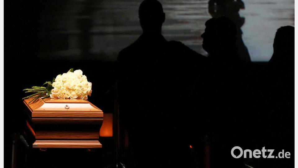 Auf dem Sarg liegt ein Strauß weißer Rosen. Bild: Antonio Calanni/AP/dpa