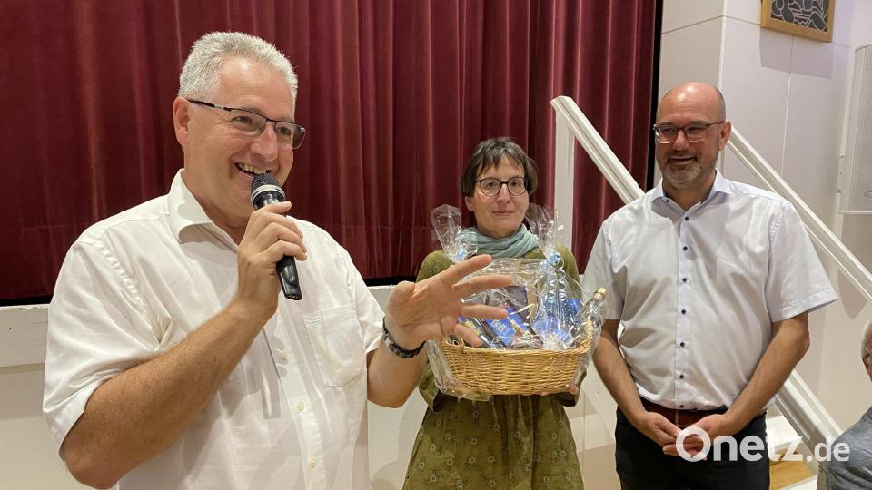 Stadtpfarrer Hannes Lorenz und Pfarrgemeindesratssprecherin Tanja Raab (von links) überreichten dem neuen Mitarbeiter Thomas Kern, der von &quot;Bad&quot; Weißenstadt in die &quot;Dom&quot;-Stadt Nabburg wechselt, beim Empfang im Jugendwerk zum besseren Einstieg einen Korb mit &quot;Dom&quot;-Genüssen. Bild: aub