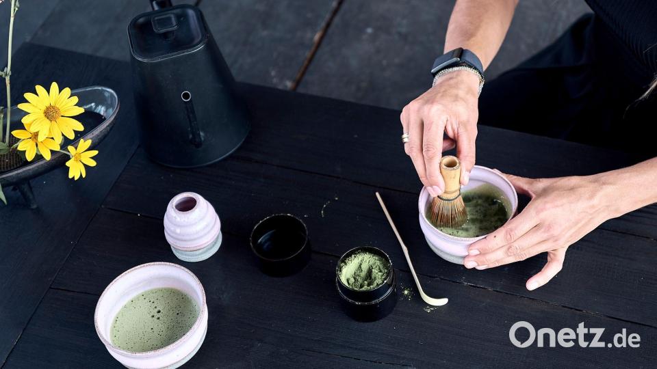 Das Matcha-Pulver wird mit Wasser und einem Besen schaumig geschlagen. Bild: Michael Ukas/dpa