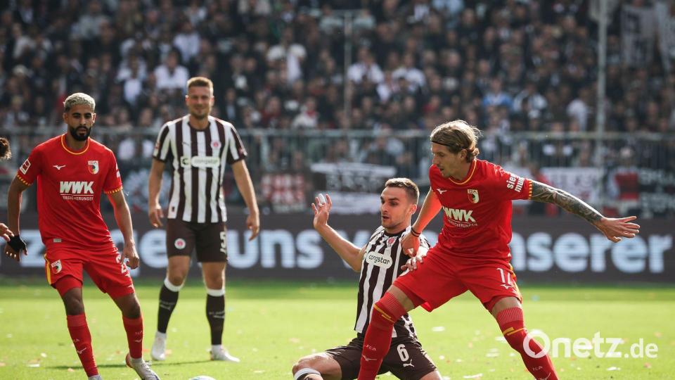Im Zweikampf: Kristijan Jakić vom FC Augsburg (r) und St. Paulis James Sands. Bild: Christian Charisius/dpa