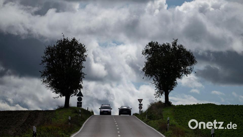 Dunkle Wolken über einer Landstraße in Baden-Württemberg. Bild: Marijan Murat/dpa