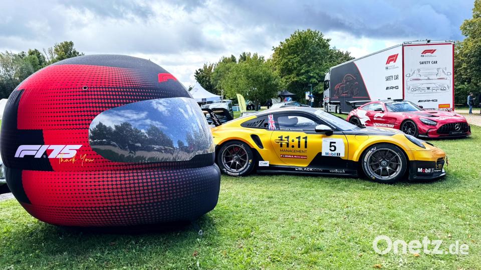 Als Symbol für die Welt des Motorsports war ein überdimensionaler Helm aufgestellt, daneben ein in Porsche-Mobil-1-Supercup-Rennen erprobter Porsche 911 GT3 Cup und dahinter ein Safetycar, ein Mercedes-AMG V8-Biturbomotor-Fahrzeug. Bild: Peter Ringeisen