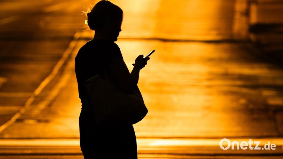 Eine Frau mit Handy - in der Netflix-Doku „Unbekannte Nummer: Der Highschool-Catfish“ kommt der Psychoterror via Smartphone. (Symbolbild) Bild: Julian Stratenschulte/dpa