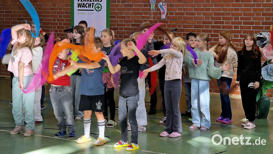 Mit farbigen Tüchern, Gesang und rhythmischem Klatschen brachte die Klasse 4b ein kleines „Hörgeschenk“ dar: Das Lied „Augen auf im Verkehr“ mahnte musikalisch zu Aufmerksamkeit und Vorsicht. Bild: R. Kreuzer