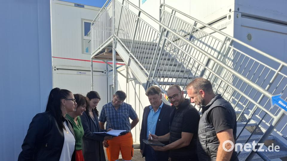 Stellvertretende Kindergartenleiterin Corina Vrella, Dritte Bürgermeisterin Theresia Dobler, Verwaltungsangestellte Verena Steinsdorfer, Markus Ries vom Bauhof, amtierender Bürgermeister Andreas Altmann, Architekt Konrad Kraus und Christian Winkler von der Firma “all2work“ (von links) begutachten nochmals die Pläne und sind erleichtert: Die Containeranlage (im Hintergrund) ist fertiggestellt und sehr gut gelungen. Bild: jua
