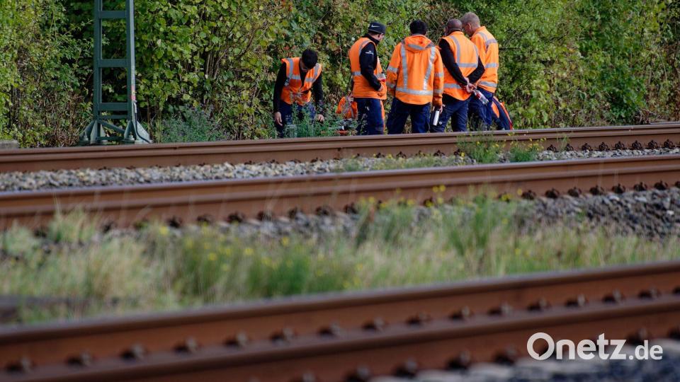 Bahn-Mitarbeiter stehen am Rand der Strecke Köln-Düsseldorf. Bild: Henning Kaiser/dpa